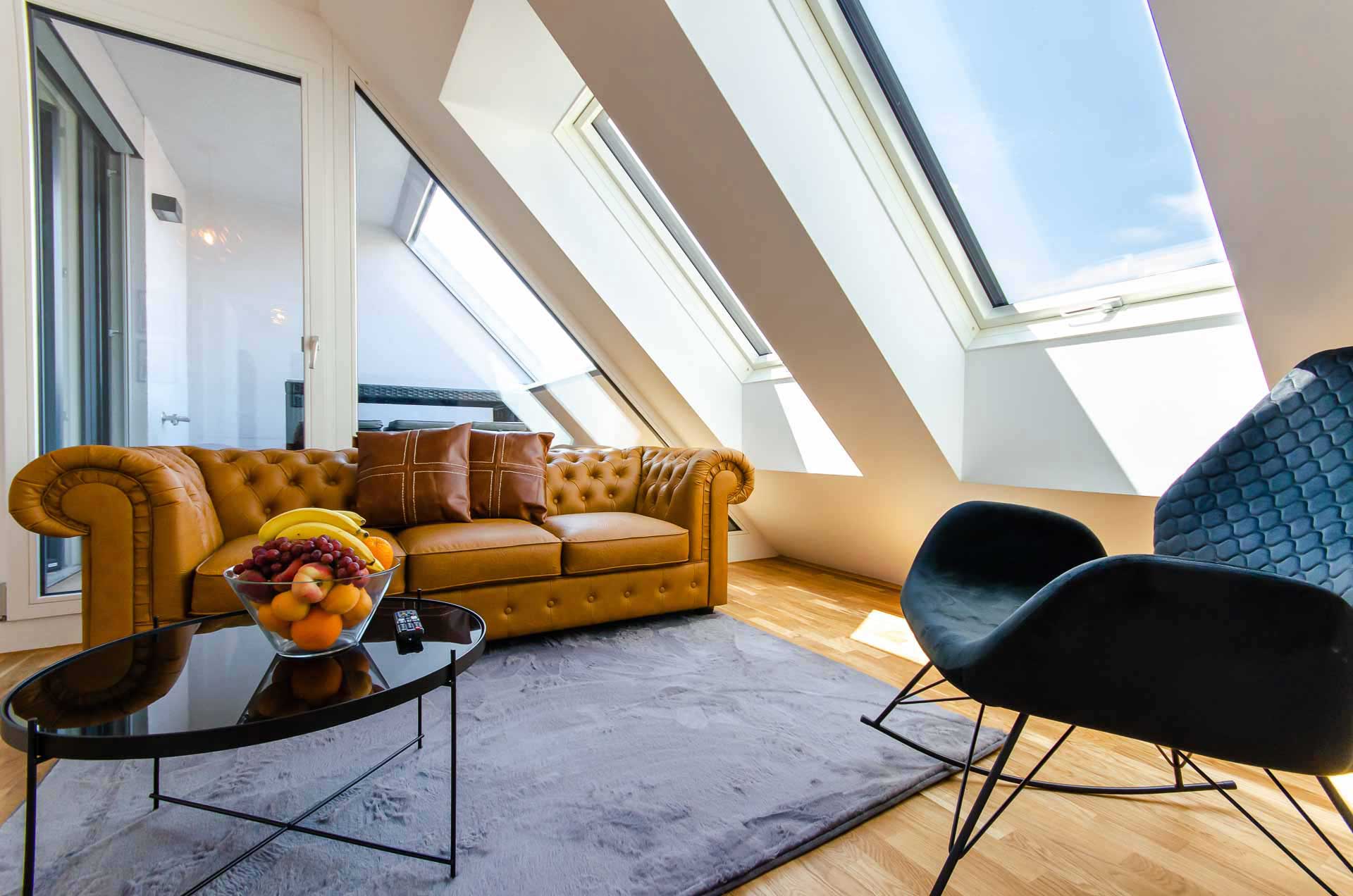 Bright loft living room with skylights, leather sofa and modern decor