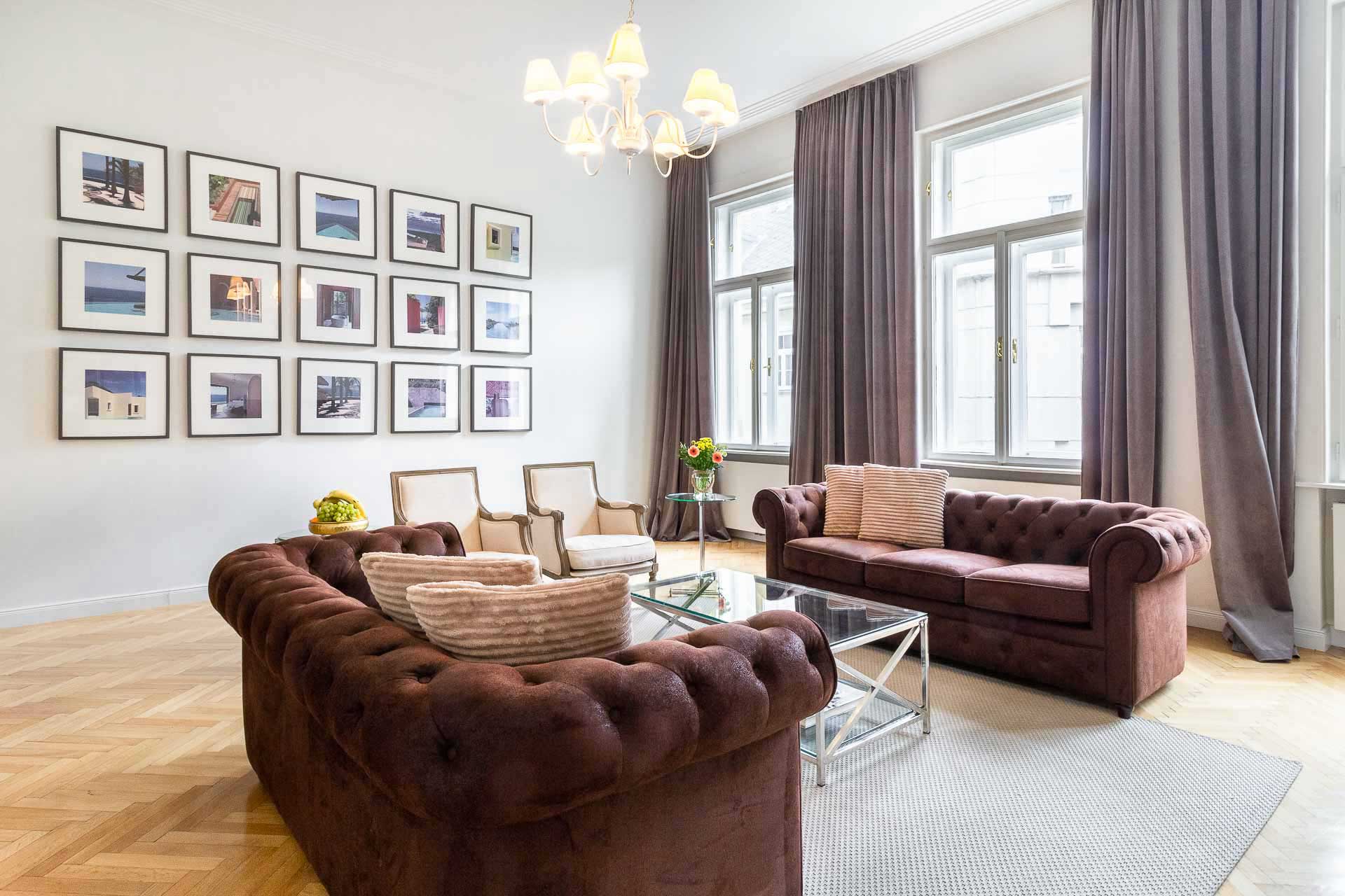 Luxurious couches with colorful pictures in the background in a light flooded 3 room apartment in Vienna