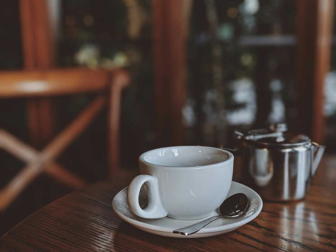 Clean white coffee mug on a wooden table in Vienna in the 8th district