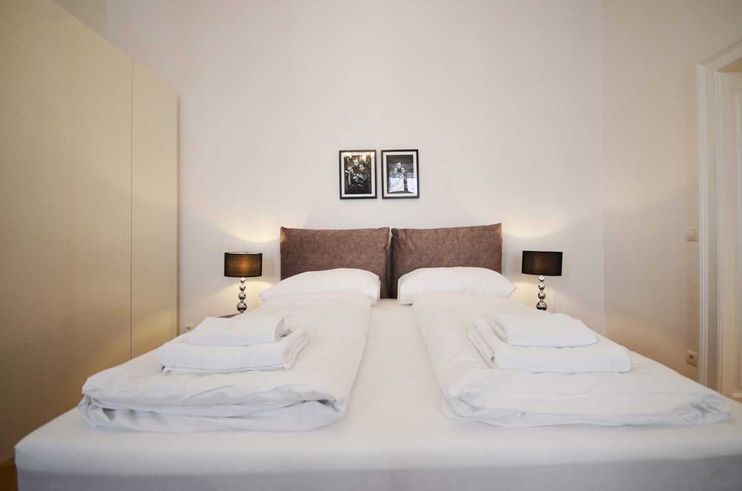 Cozy kingsize bed with fresh linen and towels on it