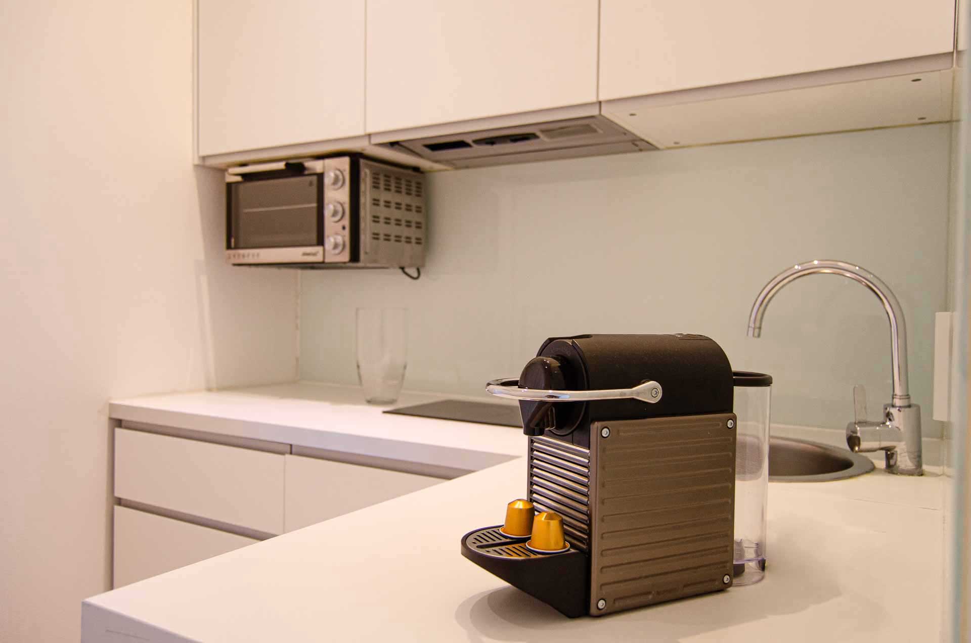 Coffee machine on kitchen counter in modern, clean white kitchen