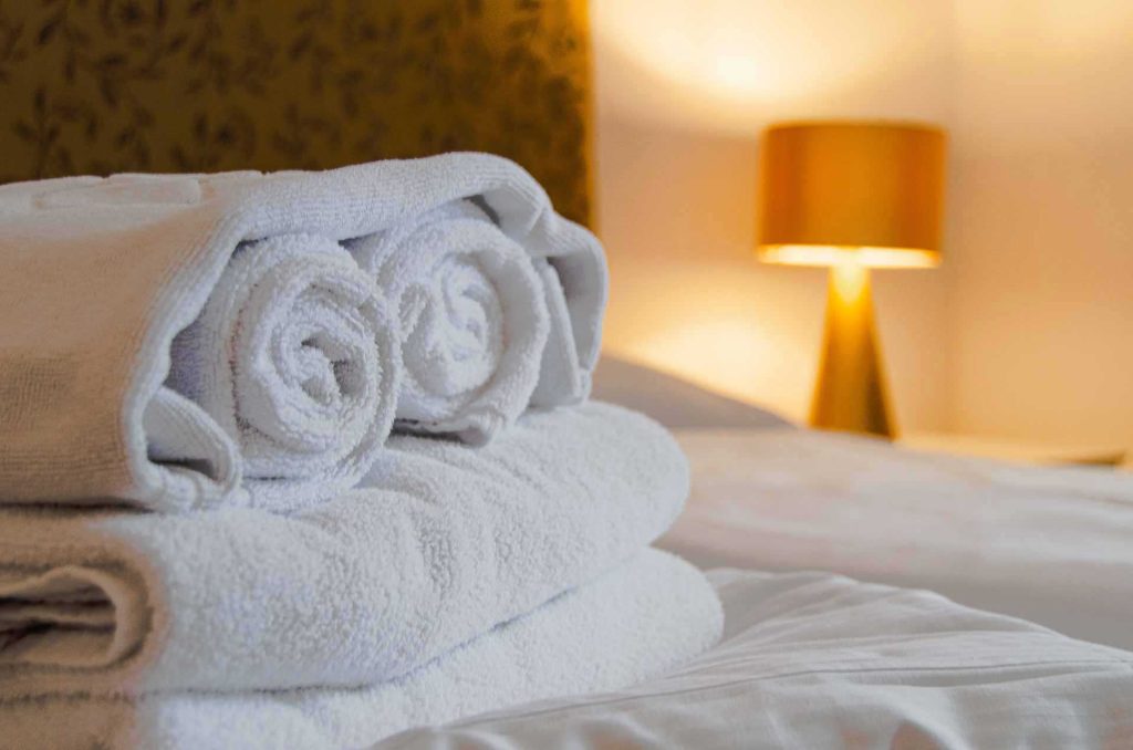 fresh linen and clean towels on kingsize bed