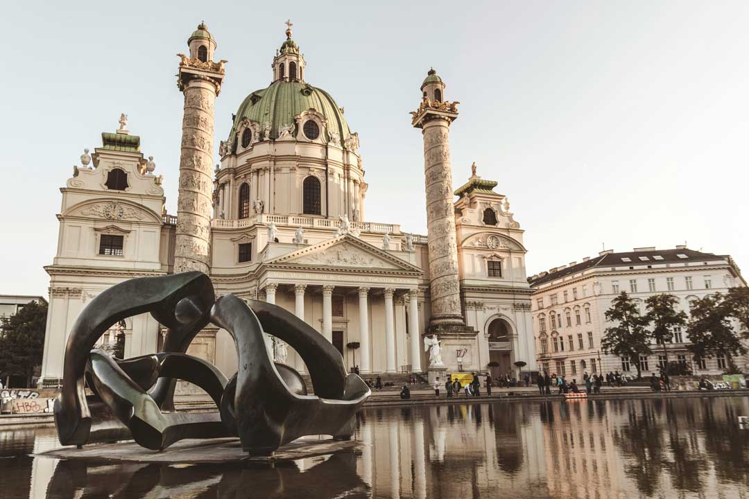 Amazing view at Karlskirche in Viennas 4th district, with blue sky in the back an d a nice lake in the front