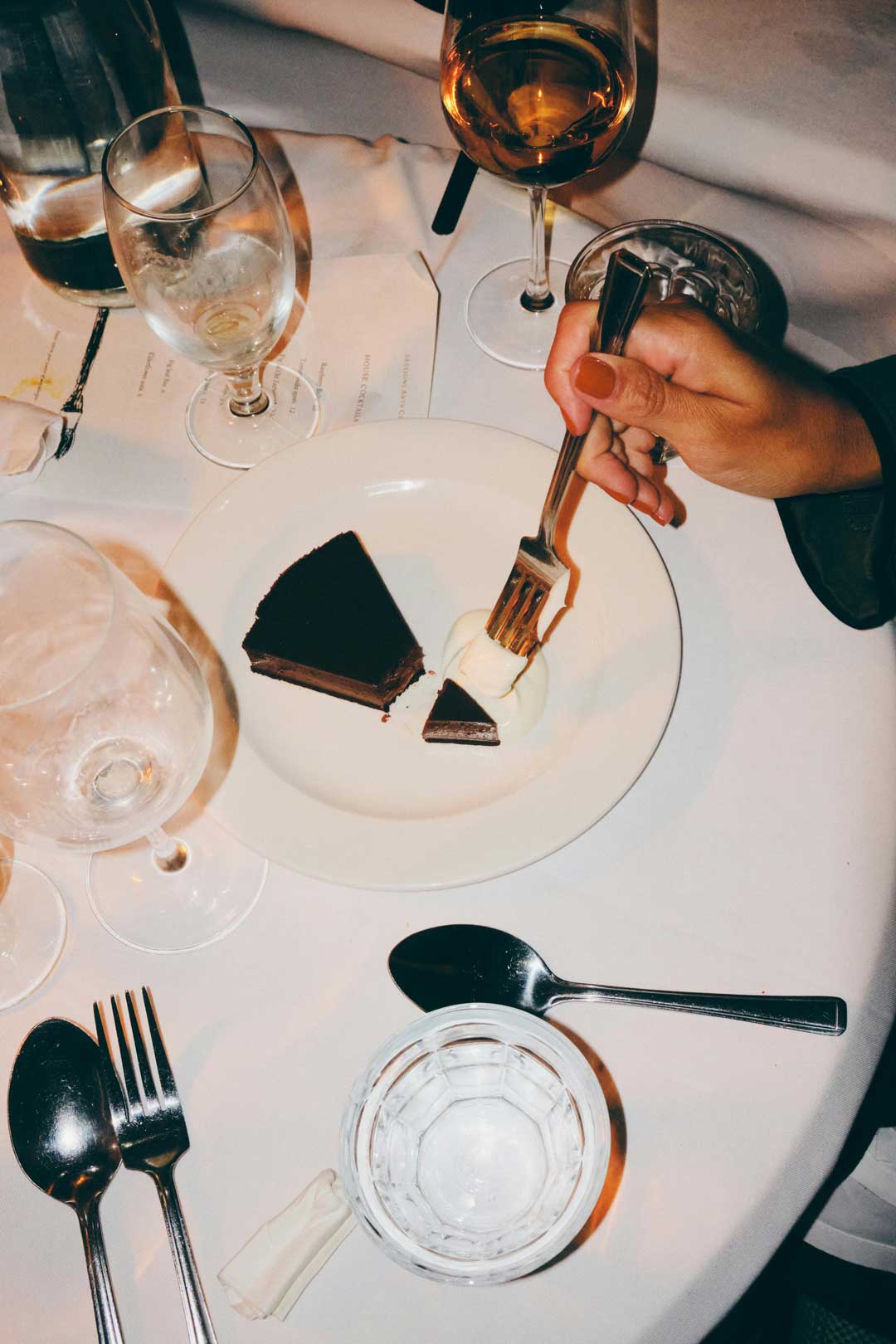 Sachertorte (Cake) on a table with a fresh white tablecloth and drinks on top, in Viennas 4th district