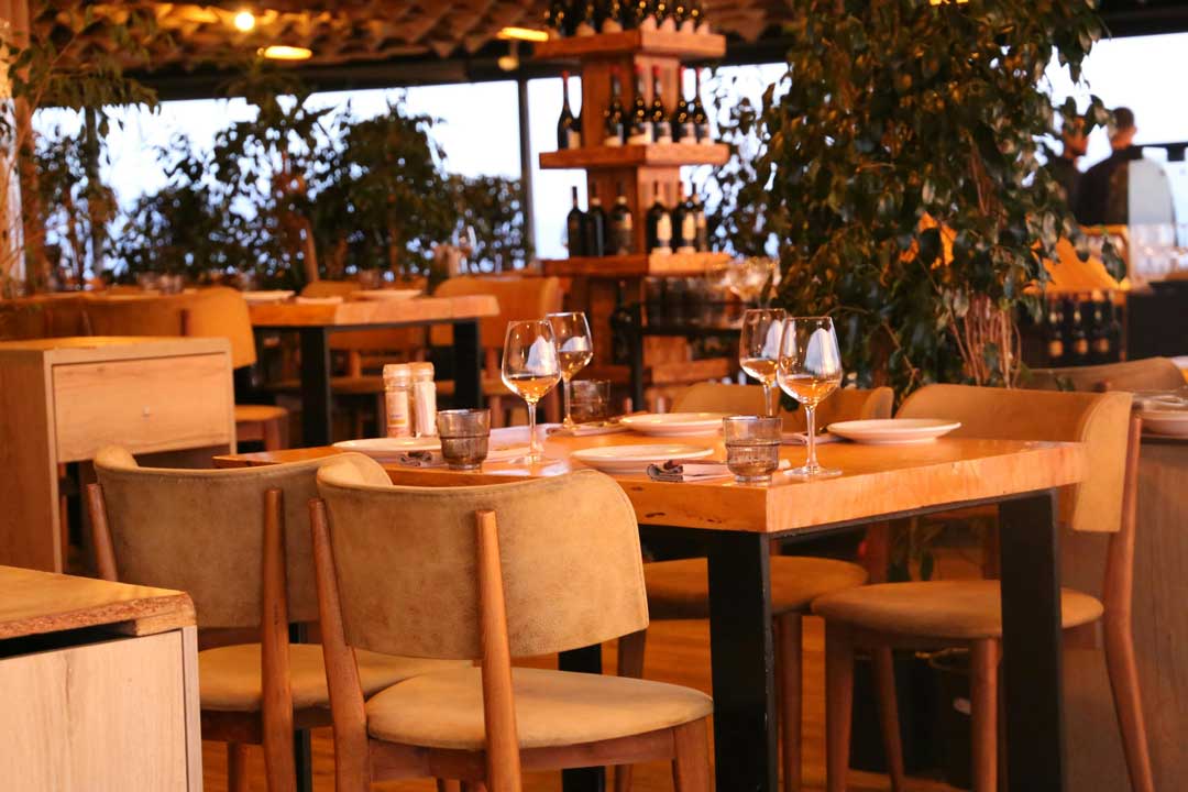 Restaurant interior: a modern wooden table with elegant chairs and glasswear in Vienna in the 20th district