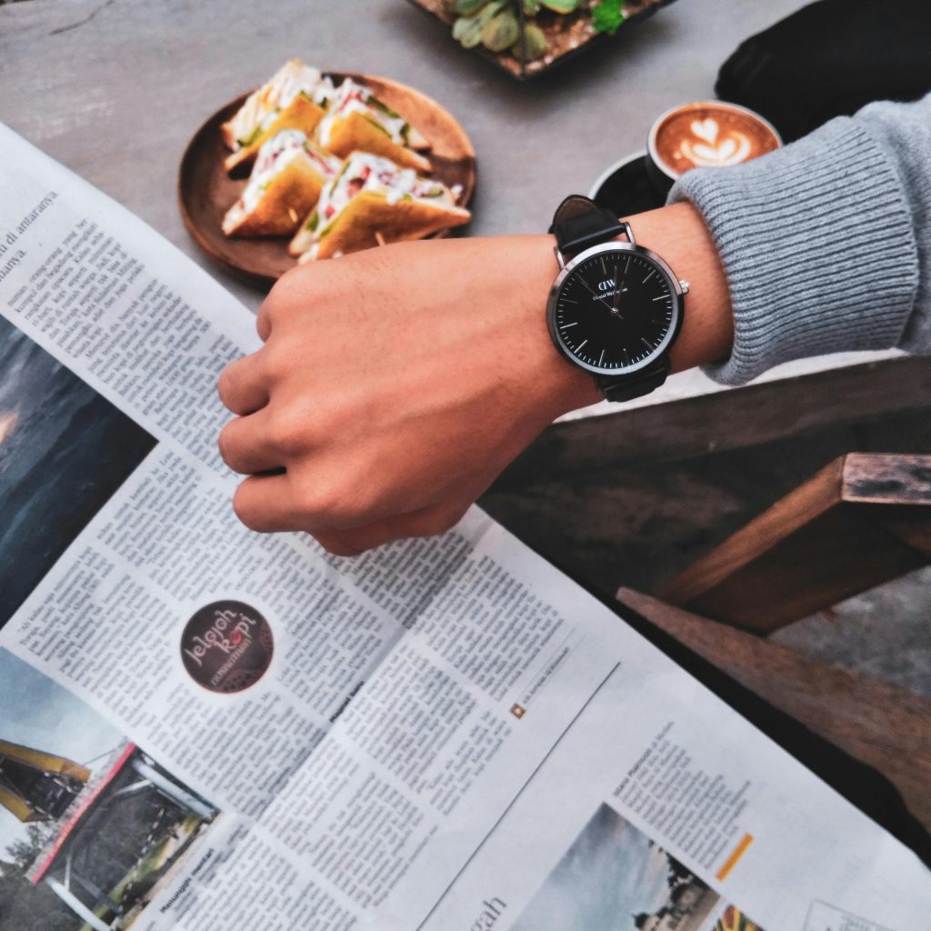 A person having breakfast while looking at their watch
